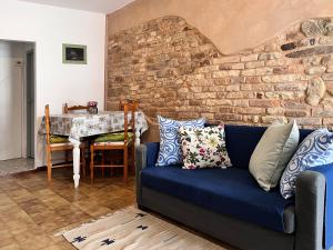 a living room with a blue couch and a brick wall at Civico 19 in Belmonte Piceno