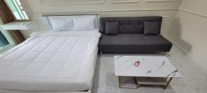 łóżko i kanapa w małym pokoju w obiekcie Vacation pool condo w mieście Ban Rangeng