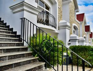 una casa con escaleras y barandilla de hierro forjado en Five Homes Hotel and Apartments en Abuja