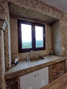 a kitchen counter with a sink and two windows at Casa O Sopé in Filgueira +48 photos