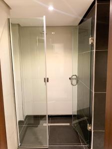 a shower with a glass door in a bathroom at Five Homes Hotel and Apartments in Abuja