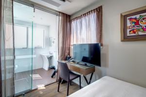 a hotel room with a desk with a television and a bathroom at 57Hotel in Sydney