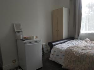 um pequeno quarto com uma cama, uma cómoda e uma saia-cama em A Quiet & Comfortable 4 Bedroom house em Manchester