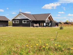a house with a grass field in front of it at 6 person holiday home in Hadsund in Øster Hurup