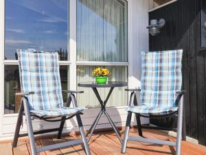 6 person holiday home in Hadsund في Øster Hurup: كرسيين وطاولة على الشرفة