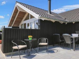 um pátio com cadeiras, uma mesa e uma casa em 6 person holiday home in Hadsund em Øster Hurup