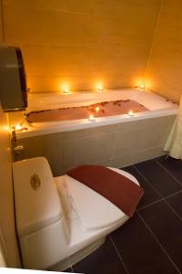 ein Bad mit einem WC und einer Badewanne mit Beleuchtung in der Unterkunft Grand World Hotel in Johor Bahru