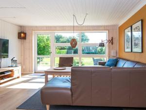ein Wohnzimmer mit einem Sofa und einem Tisch in der Unterkunft Holiday home Bjert XIX in Binderup Strand
