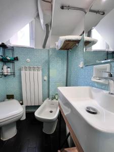 uma casa de banho com um lavatório branco e um WC. em Civico 19 em Belmonte Piceno