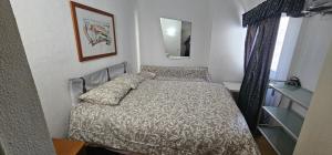 una piccola camera con letto e specchio di Summer Beach Hoster a Costa da Caparica