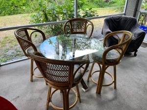 a glass table and four chairs on a porch at Grandma’s White House in Palm Coast