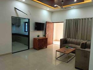 a living room with a couch and a table at Modern & homely 3bhk city centre in Jaipur