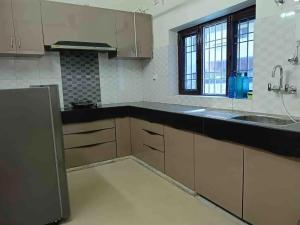 a kitchen with brown cabinets and a black counter top at Modern & homely 3bhk city centre in Jaipur