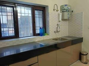 a kitchen with a sink and two windows at Modern & homely 3bhk city centre in Jaipur