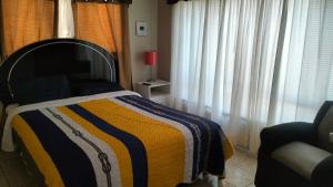 a bedroom with a bed with a striped blanket at Geranios in Ciudad Juárez