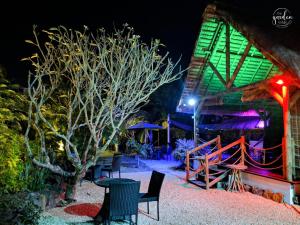 a group of chairs sitting outside of a building at night at Garden lodge in Pereybere