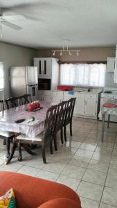 eine Küche mit einem Tisch und Stühlen sowie eine Küche mit weißen Schränken in der Unterkunft Geranios in Ciudad Juárez