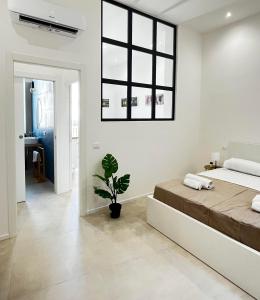 a bedroom with a large bed and a potted plant at Valguarnera Studio Apartments in Palermo