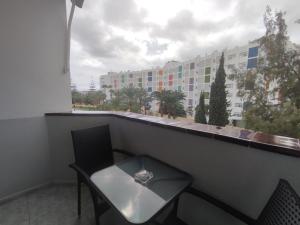 uma mesa e cadeiras numa varanda com vista para um edifício em Vivienda Agaete Parque em Playa del Inglés