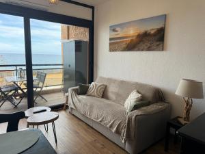sala de estar con sofá y vistas al océano en Appartement n 302 moriani plage, en Moriani Plage
