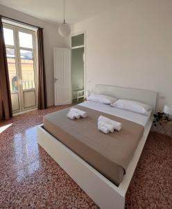 a bedroom with a large bed with towels on it at Valguarnera Studio Apartments in Palermo