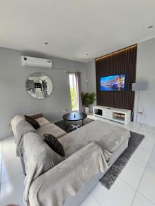 a living room with a couch and a flat screen tv at Belle Luxury Apartments in Gros Islet