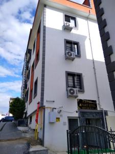 un edificio blanco con dos ventanas y un cartel en él en miamia apart otel en Bostancı