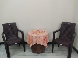 duas cadeiras e uma mesa com uma toalha de mesa em Nature's Paradise Homestay em Haridwar