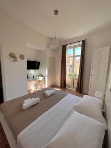 a large white bedroom with two beds and a window at Valguarnera Studio Apartments in Palermo
