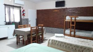 a bedroom with a bed and a table and a bunk bed at Monoambientes Bajos Medanales in Victorica +10 photos