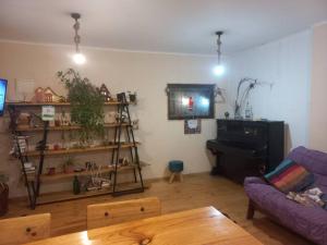 a living room with a purple couch and a tv at Acogedora y amplia Casa in Puchuncaví