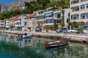 two boats are docked in the water next to buildings at Apartments by the sea Drasnice, Makarska - 2722 in Drasnice