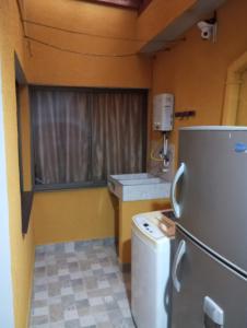 a small kitchen with a refrigerator and a window at Habitación # 1 Moderna y Cómoda in Bello