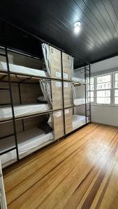 a room filled with bunk beds with a wooden floor at Hostel Hug Brasil in Curitiba