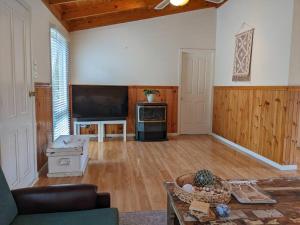 a living room with a couch and a tv at beach house in Venus Bay