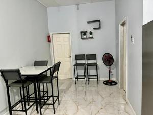 a dining room with chairs and a table and a fan at Piarco Airport Guest House in Piarco