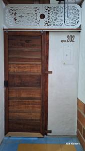 una puerta de madera en una habitación con pared en Villa Linda ApartaHotel, en Jericó