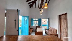 a room with wooden benches and a blue door at Villa Linda ApartaHotel in Jericó