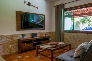 a living room with a flat screen tv on the wall at Bella casa da paz in Búzios