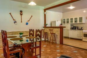 a kitchen with a table and some baseball bats on the wall at Bella casa da paz in Búzios