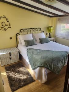 ein Schlafzimmer mit einem großen Bett mit weißer Bettwäsche und Kissen in der Unterkunft El rincón de Mónica in A Coruña