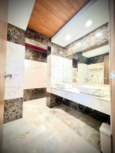 La salle de bains est pourvue de 2 lavabos, d'une baignoire et de toilettes. dans l'établissement Villa 7 bedrooms, à Ban Mai Salae