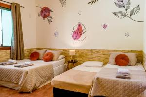 two beds in a room with butterflies on the wall at Bella casa da paz in Búzios