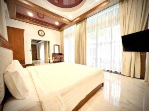 a bedroom with a large white bed and a large window at Villa 7 bedrooms in Ban Mai Salae