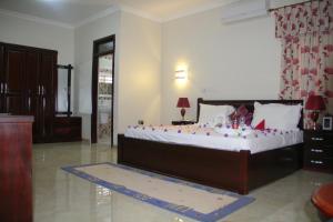 Un dormitorio con una cama grande con adornos. en Gold Plus Hotel Ghana en Kumasi