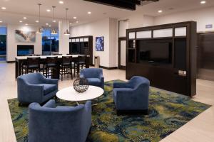 a lobby with chairs and a table and a dining room at Holiday Inn & Suites - Farmington Hills - Detroit NW, an IHG Hotel in Farmington Hills