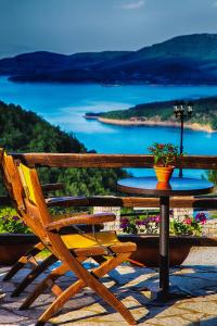 a table and chairs on a patio with a view of the water at Χρυσοπελεια - Chrisopeleia Lake View in Neochori