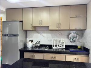 a kitchen with white cabinets and a refrigerator at Duplex panoramique avec jardin in Chefchaouen