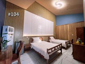 um quarto com duas camas e uma televisão em Grand Leone Hotel em Freetown