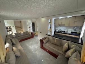 ein großes Wohnzimmer mit Sofas und einer Küche in der Unterkunft Duplex panoramique avec jardin in Chefchaouen